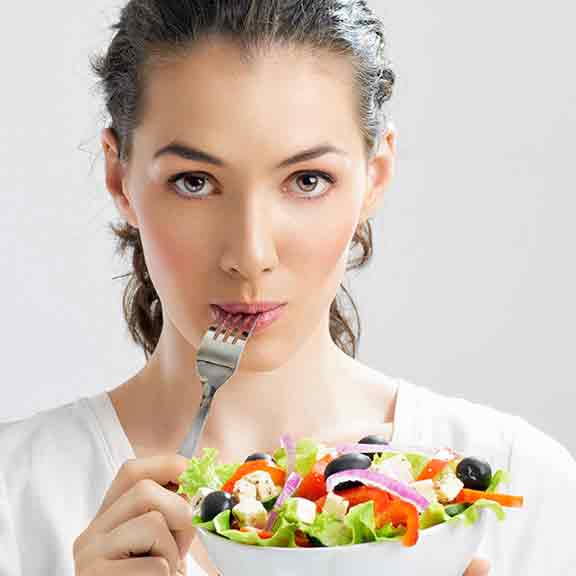 woman with fork in mouth eating salad square