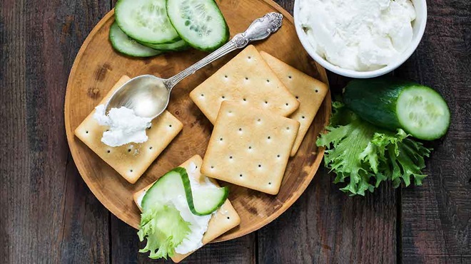 crackers with dip and cucumber on a plate