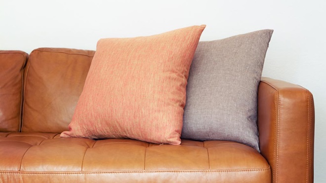 tan leather couch with pillows lead