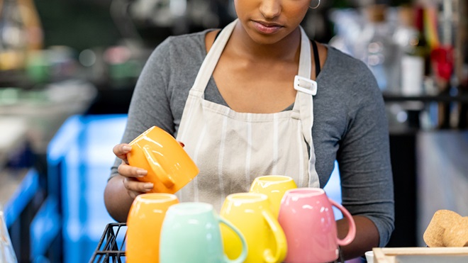 migrant worker in cafe washing up crockery