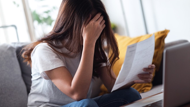 woman_with_hand_over_face_looking_at_document