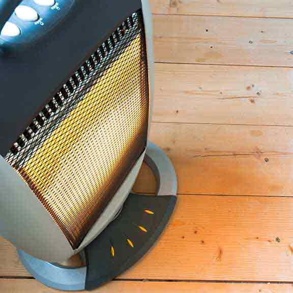 Electric heater on wooden floor