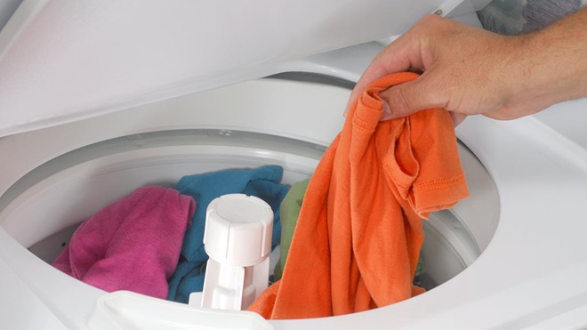 Adding clothes to to a top loading washing machine