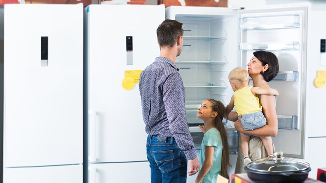family looking at different size fridges