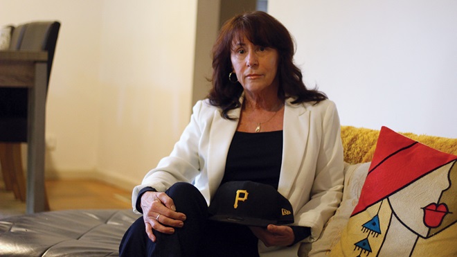 libby sitting at home holding her son bens baseball cap