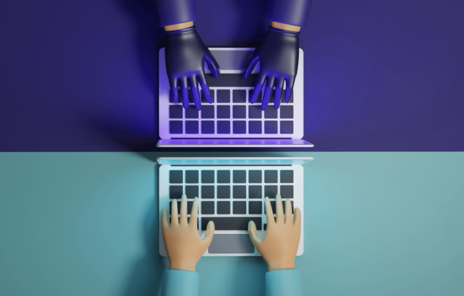 two sets of hands at adjacent laptops