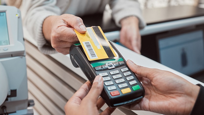 person tapping debit card on card reader