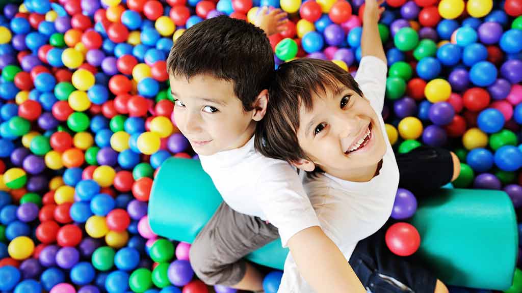 two children in ball pit playing safety