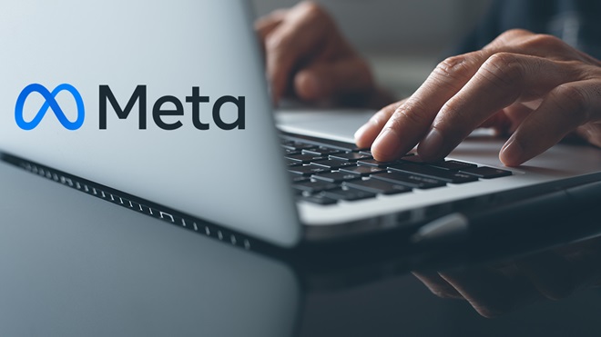 person typing on laptop and meta logo