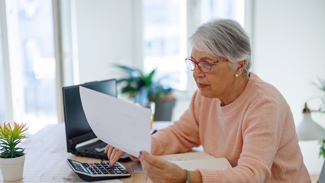 senior person with laptop calculating health insurance costs