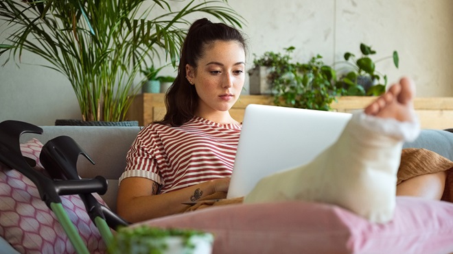 person_with_broken_leg_typing_on_a_laptop