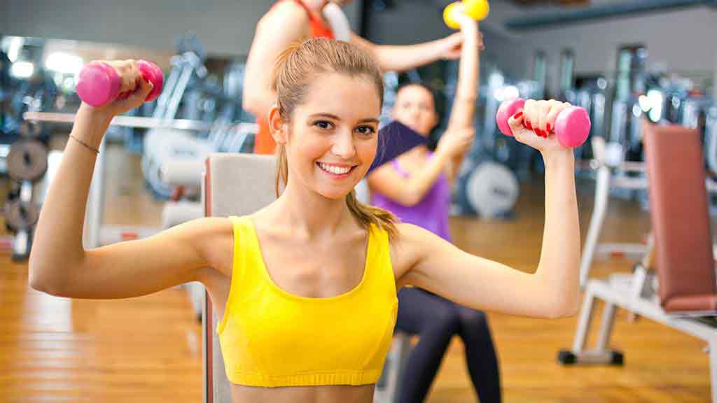 gym and gym membership lady holding weights at gym