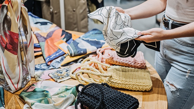 person looking at scarf in op shop