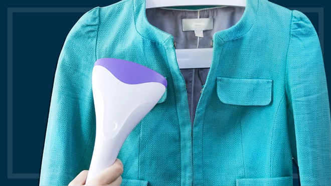 using a garment steamer on a teal jacket