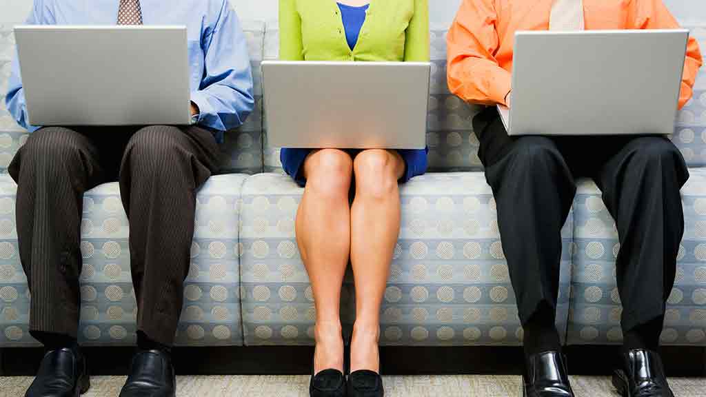 three people sitting with laptops