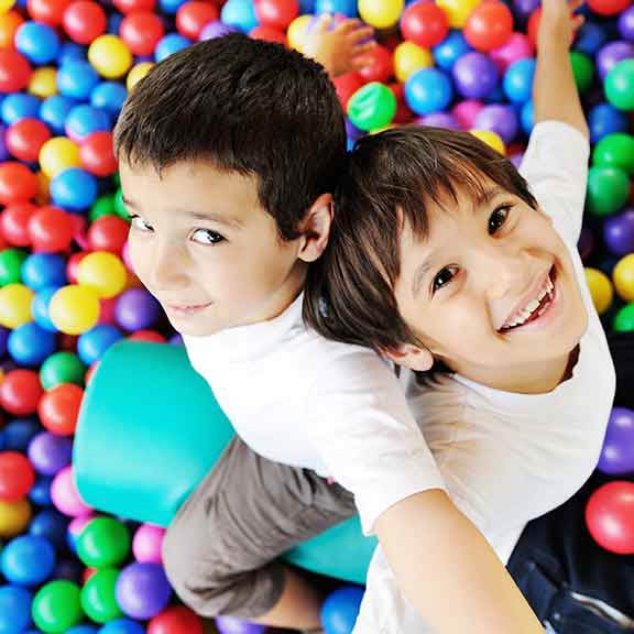 two children in ball pit playing safety sq
