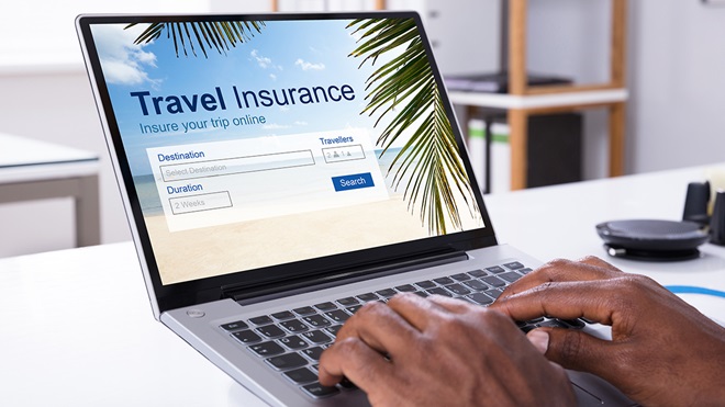 checking travel insurance policies on laptop