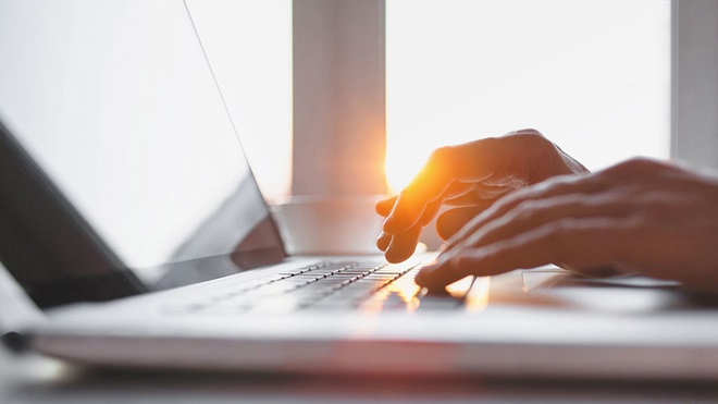 hands typing on laptop keyboard