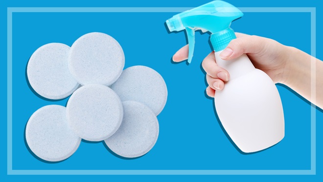 cleaning tablets hand holding spray bottle on blue