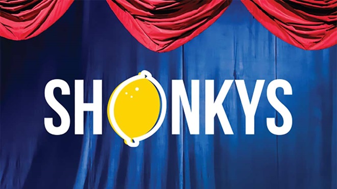 shonkys logo in front of  stage curtain